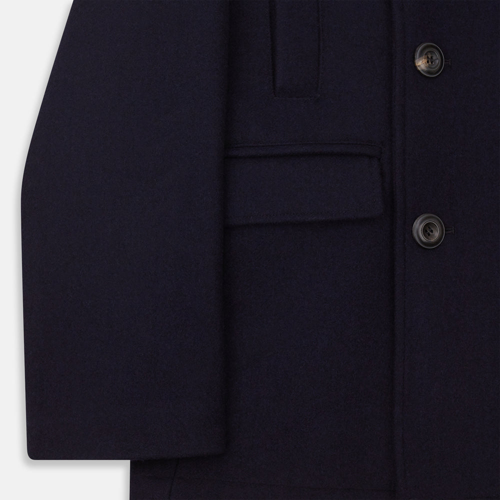 The Navy Lambswool Redford Peacoat by Turnbull & Asser is a double-breasted navy outerwear with black buttons, broad lapels, slanted pockets, and a striking deep red inner lining.