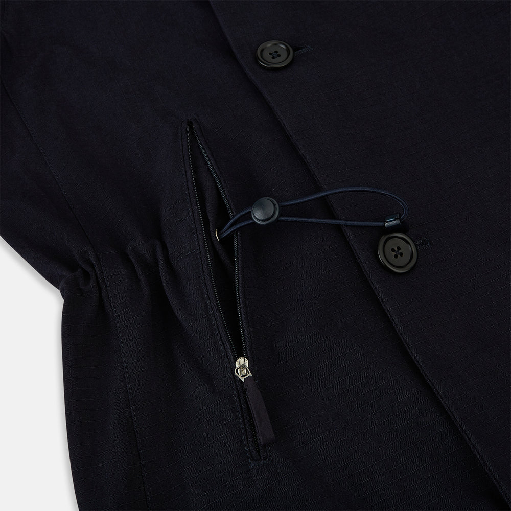 The Navy Short Albert Trench Coat by Turnbull & Asser UK features dark navy fabric, six black buttons, a notched collar, long sleeves with adjustable cuffs, and front zip pockets—displayed on a plain white background.