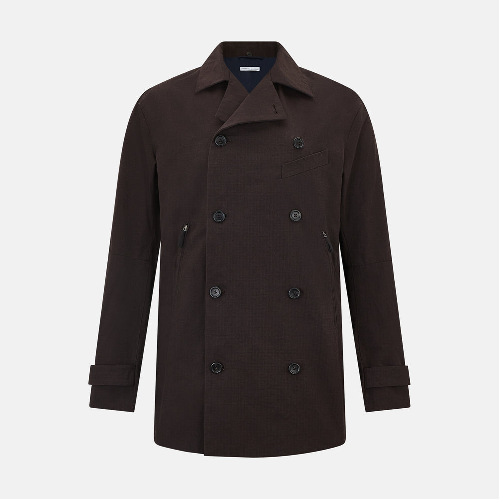 The Turnbull & Asser UK Dark Chocolate Short Albert Trench Coat features a double-breasted style, black buttons, notched collar, chest pocket, two side zip pockets, and adjustable cuff straps—shown on a plain white background.