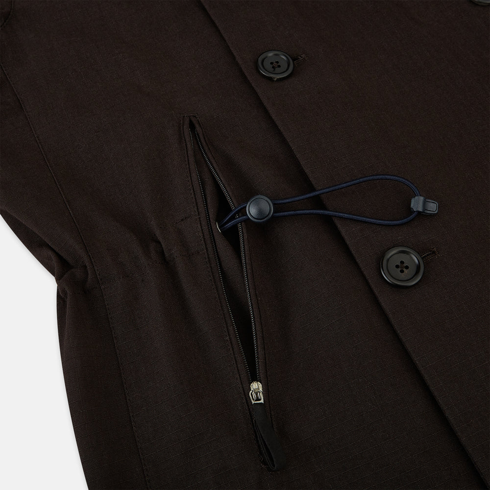 The Turnbull & Asser UK Dark Chocolate Short Albert Trench Coat features a double-breasted style, black buttons, notched collar, chest pocket, two side zip pockets, and adjustable cuff straps—shown on a plain white background.