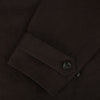 View 4 of product The Turnbull & Asser UK Dark Chocolate Short Albert Trench Coat features a double-breasted style, black buttons, notched collar, chest pocket, two side zip pockets, and adjustable cuff straps—shown on a plain white background.