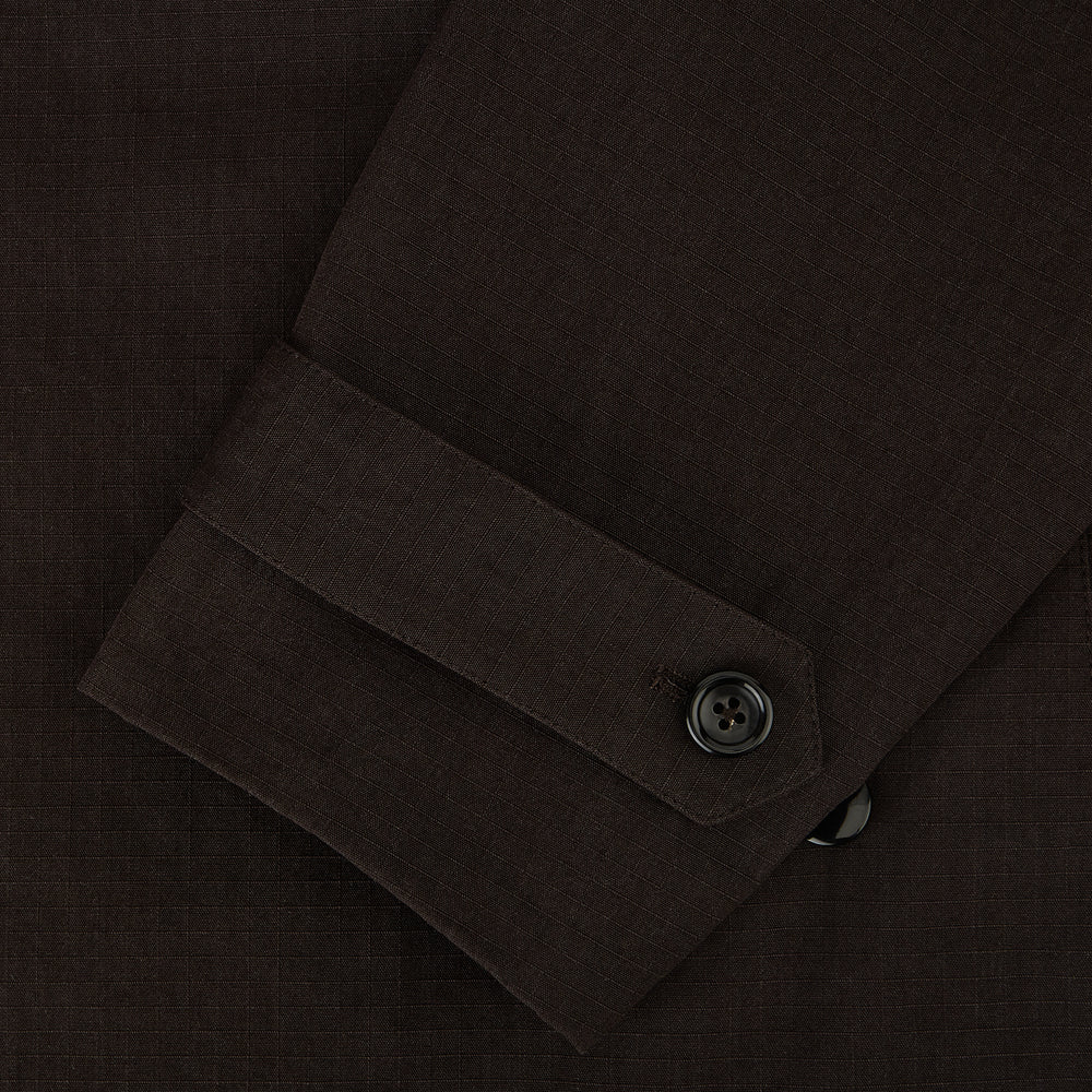 The Turnbull & Asser UK Dark Chocolate Short Albert Trench Coat features a double-breasted style, black buttons, notched collar, chest pocket, two side zip pockets, and adjustable cuff straps—shown on a plain white background.