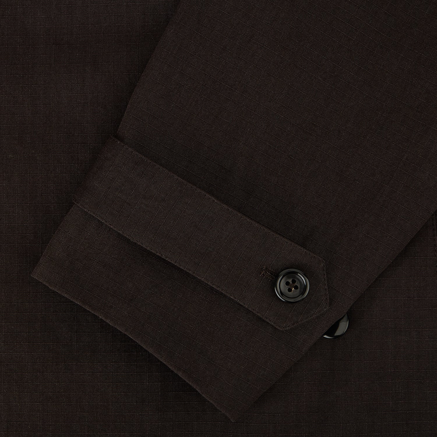 View 4 of product The Turnbull & Asser UK Dark Chocolate Short Albert Trench Coat features a double-breasted style, black buttons, notched collar, chest pocket, two side zip pockets, and adjustable cuff straps—shown on a plain white background.
