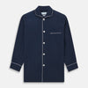View 4 of product The Turnbull & Asser Navy Piped Cotton Pyjama Set features a navy blue long-sleeve top with white piping, front buttons, a chest pocket, and matching drawstring pants, all displayed on a white background.