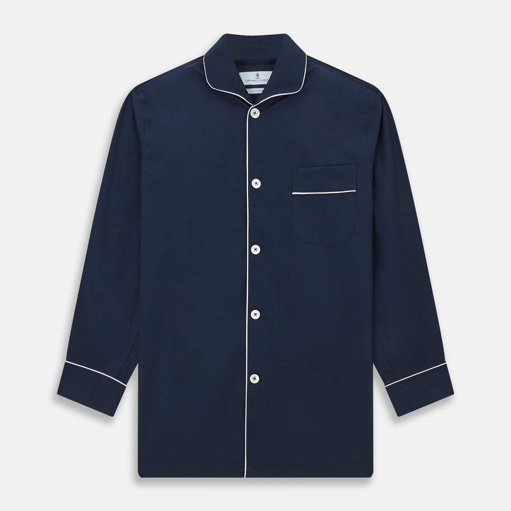 The Turnbull & Asser Navy Piped Cotton Pyjama Set features a navy blue long-sleeve top with white piping, front buttons, a chest pocket, and matching drawstring pants, all displayed on a white background.