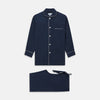 View 1 of product The Turnbull & Asser Navy Piped Cotton Pyjama Set features a navy blue long-sleeve top with white piping, front buttons, a chest pocket, and matching drawstring pants, all displayed on a white background.