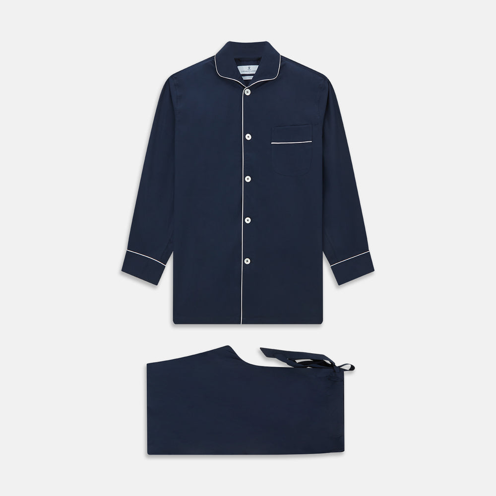 The Turnbull & Asser Navy Piped Cotton Pyjama Set features a navy blue long-sleeve top with white piping, front buttons, a chest pocket, and matching drawstring pants, all displayed on a white background.