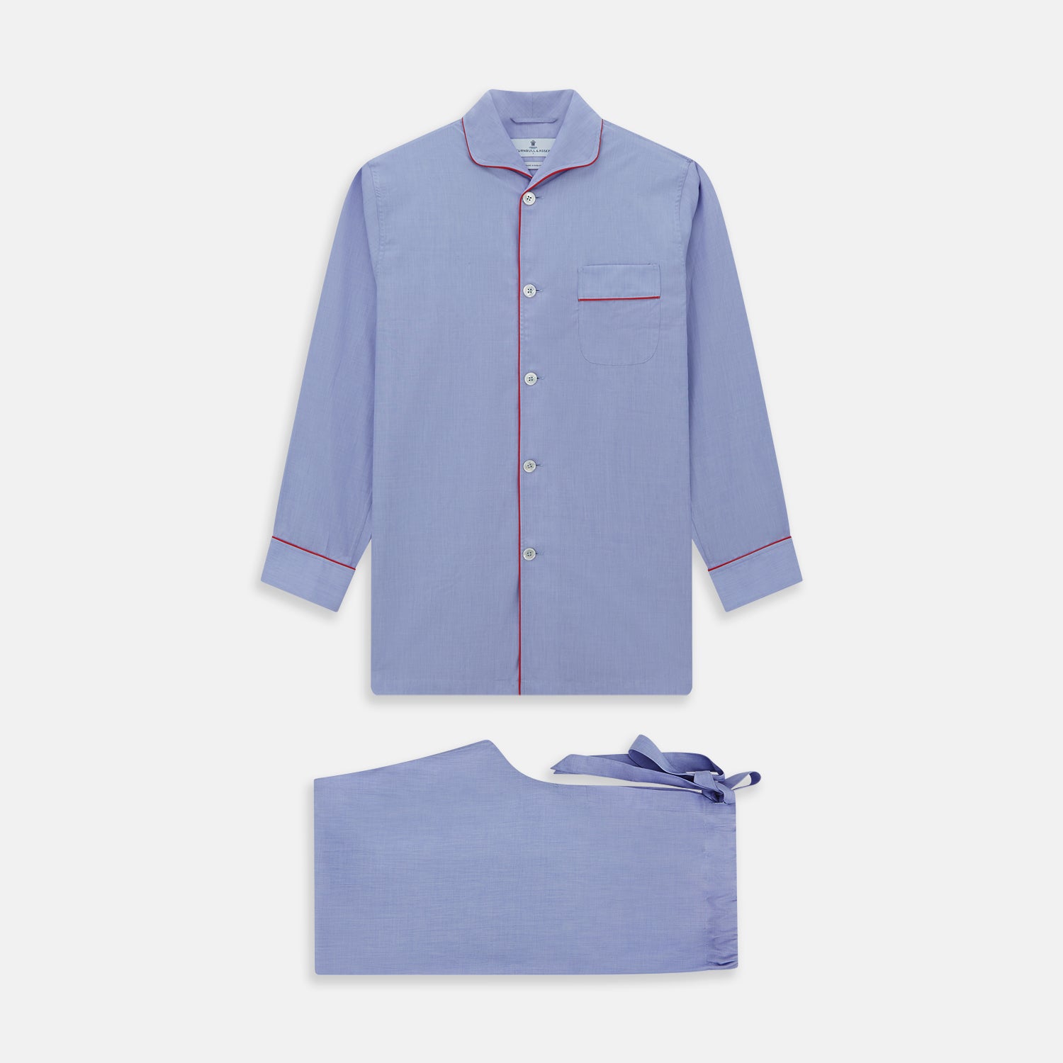 View 1 of product The Blue Piped End-on-End Cotton Pyjama Set by Turnbull & Asser features light blue long sleeves, red piping, front buttons, chest pocket, and matching drawstring pants—luxurious sleepwear laid flat on a white background.