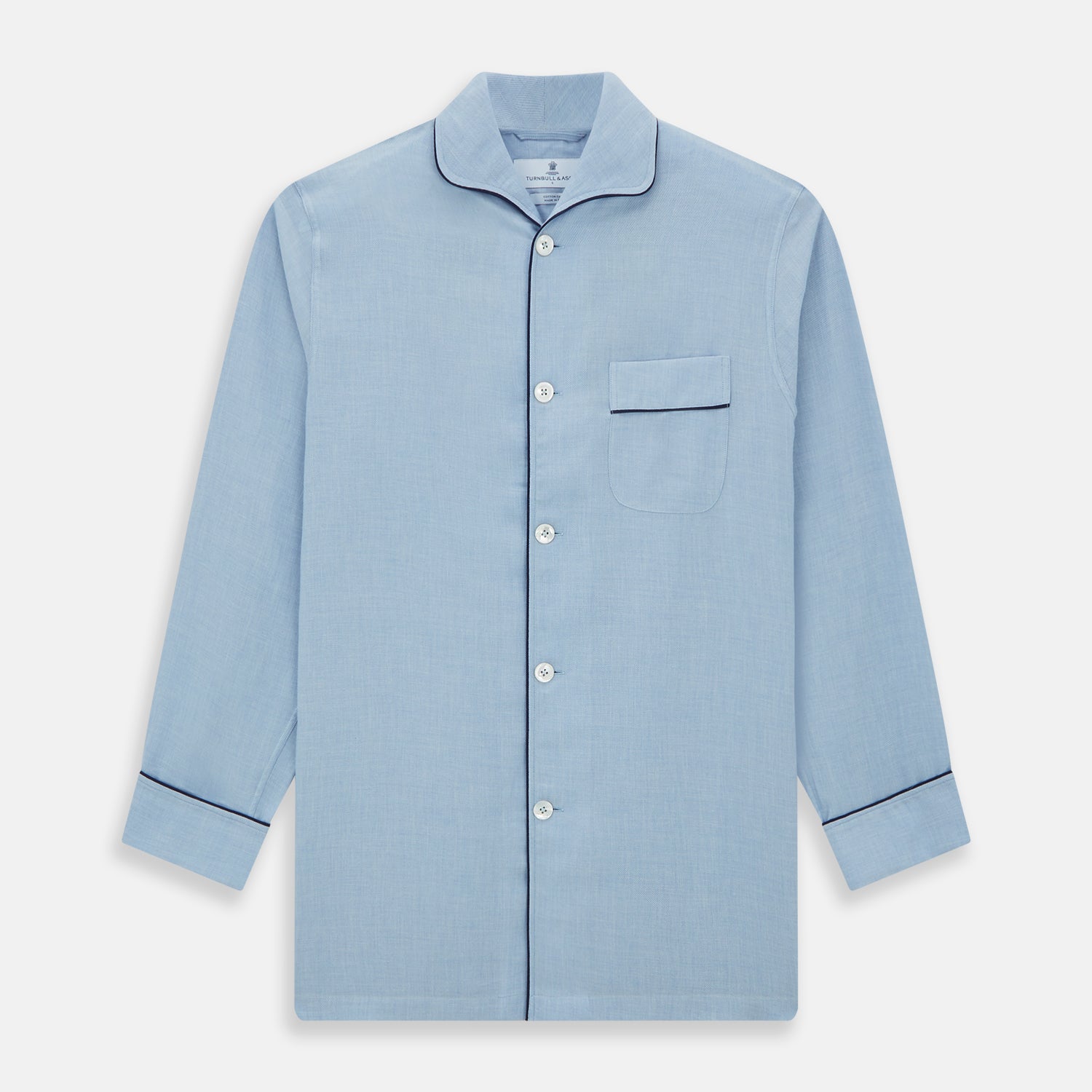 View 4 of product The Blue Piped Cotton-Cashmere Pyjama Set by Turnbull & Asser features a light blue long-sleeved, button-up top with a chest pocket and dark piping, plus matching side-tie pants—luxurious comfort displayed on a white background.