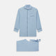 The Blue Piped Cotton-Cashmere Pyjama Set by Turnbull & Asser features a light blue long-sleeved, button-up top with a chest pocket and dark piping, plus matching side-tie pants—luxurious comfort displayed on a white background.