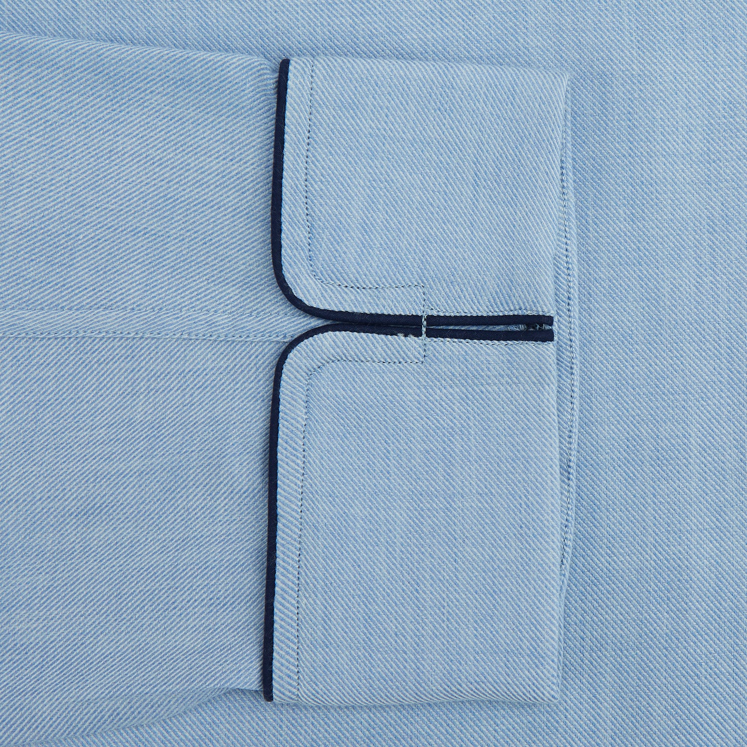 View 3 of product The Blue Piped Cotton-Cashmere Pyjama Set by Turnbull & Asser features a light blue long-sleeved, button-up top with a chest pocket and dark piping, plus matching side-tie pants—luxurious comfort displayed on a white background.