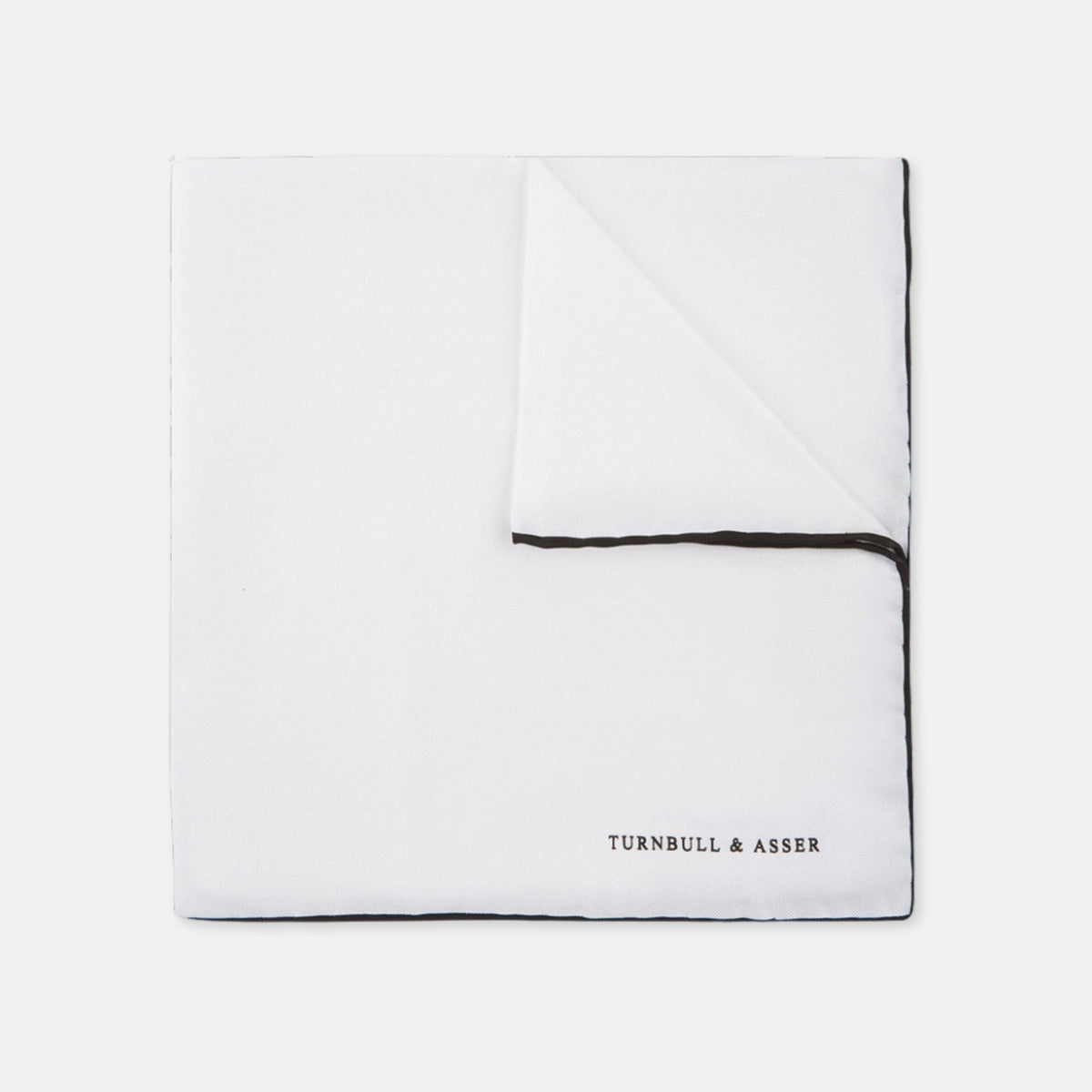 View 1 of product The Turnbull & Asser White and Black Piped Silk Pocket Square features a crisp white base with black edging, neatly folded to showcase the logo in black on the lower right—elegant monochrome style for any occasion, shown on a light gray background.