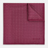 View 1 of product A folded Floral Burgundy Pocket Square in Silk by Turnbull & Asser UK, adorned with pink floral geometric motifs and featuring the Turnbull & Asser logo in the bottom right corner.
