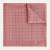 View 1 of product Introducing the Checked Pink Pocket Square in Silk from Turnbull & Asser UK, crafted with a geometric grid pattern of black lines and micro dots on soft pink silk. The design features a neatly folded corner and "Turnbull & Asser" subtly printed in the bottom right.