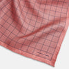 View 2 of product Introducing the Checked Pink Pocket Square in Silk from Turnbull & Asser UK, crafted with a geometric grid pattern of black lines and micro dots on soft pink silk. The design features a neatly folded corner and "Turnbull & Asser" subtly printed in the bottom right.