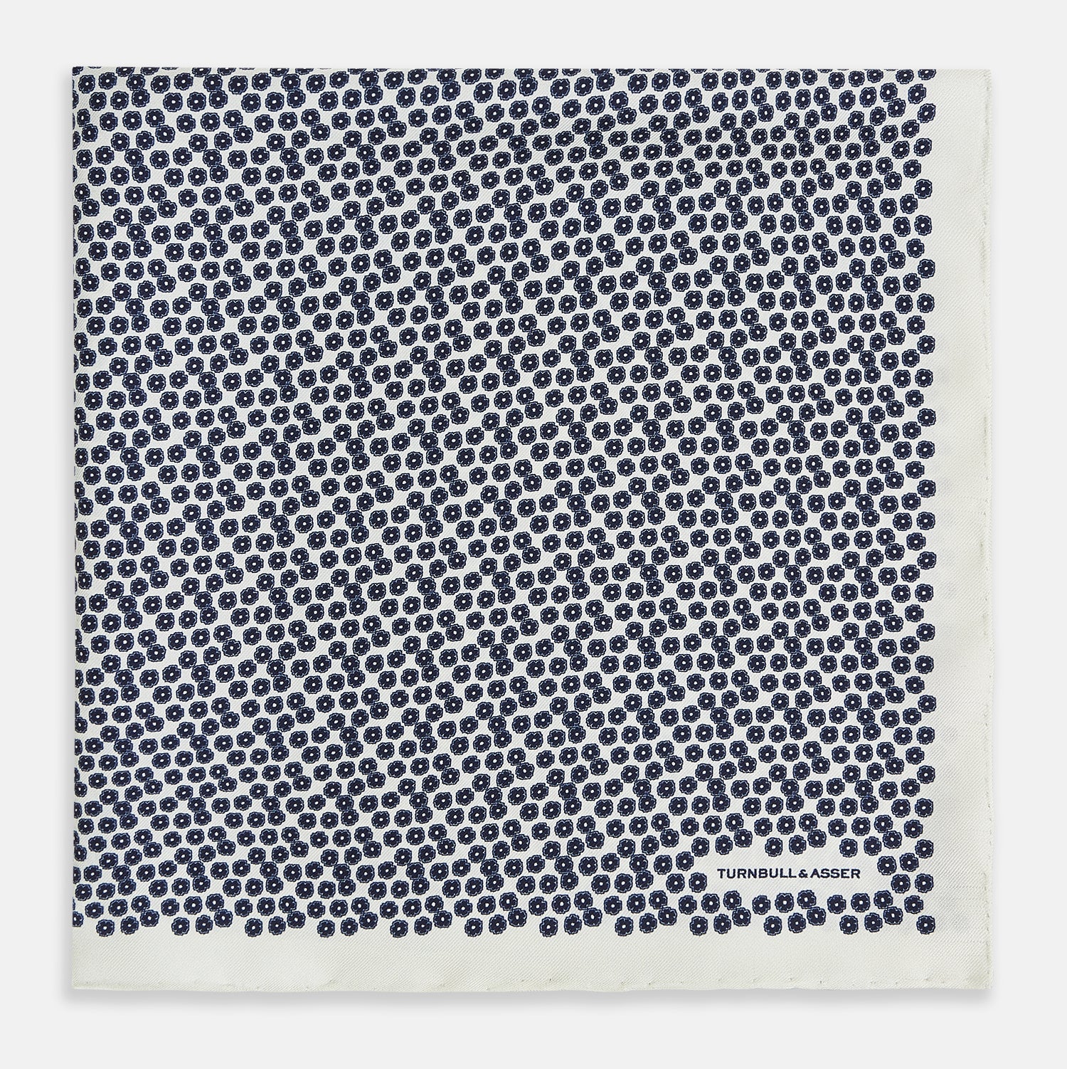 View 3 of product A refined double-sided design, the Floral White Pocket Square in Silk by Turnbull & Asser UK features a small blue floral pattern on white silk, neatly folded to display both its intricate front and bordered corner—adding subtle elegance to any ensemble.