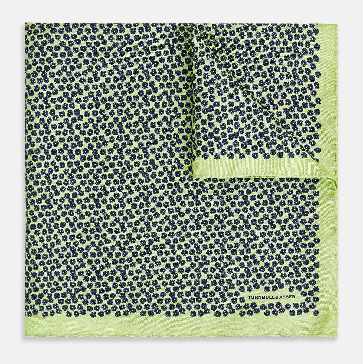 View 1 of product Introducing the Floral Green Pocket Square in Silk by Turnbull & Asser UK—a sophisticated accessory in light green silk, adorned with a delicate floral pattern and a folded corner. The pocket square features a refined double-sided design, with the Turnbull & Asser UK brand name elegantly printed on one corner.