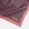 View 2 of product A folded Floral Pink Pocket Square in Silk by Turnbull & Asser UK, adorned with a pattern of small navy blue circles and the brand name printed in one corner, features a refined double-sided design for added versatility.