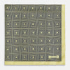 View 3 of product A checked yellow silk pocket square from Turnbull & Asser UK, featuring black and white concentric square designs with a yellow border. It is partially folded to highlight its double-sided pattern, and a small label reading TURNBULL & ASSER is visible in one corner.