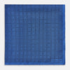 View 3 of product The Geometric Blue Pocket Square in Silk by Turnbull & Asser UK features a vibrant blue design adorned with small, outlined squares arranged in a grid of sharp navy lines. One corner is neatly folded to reveal the reverse side, with "Turnbull & Asser" printed at the bottom right.