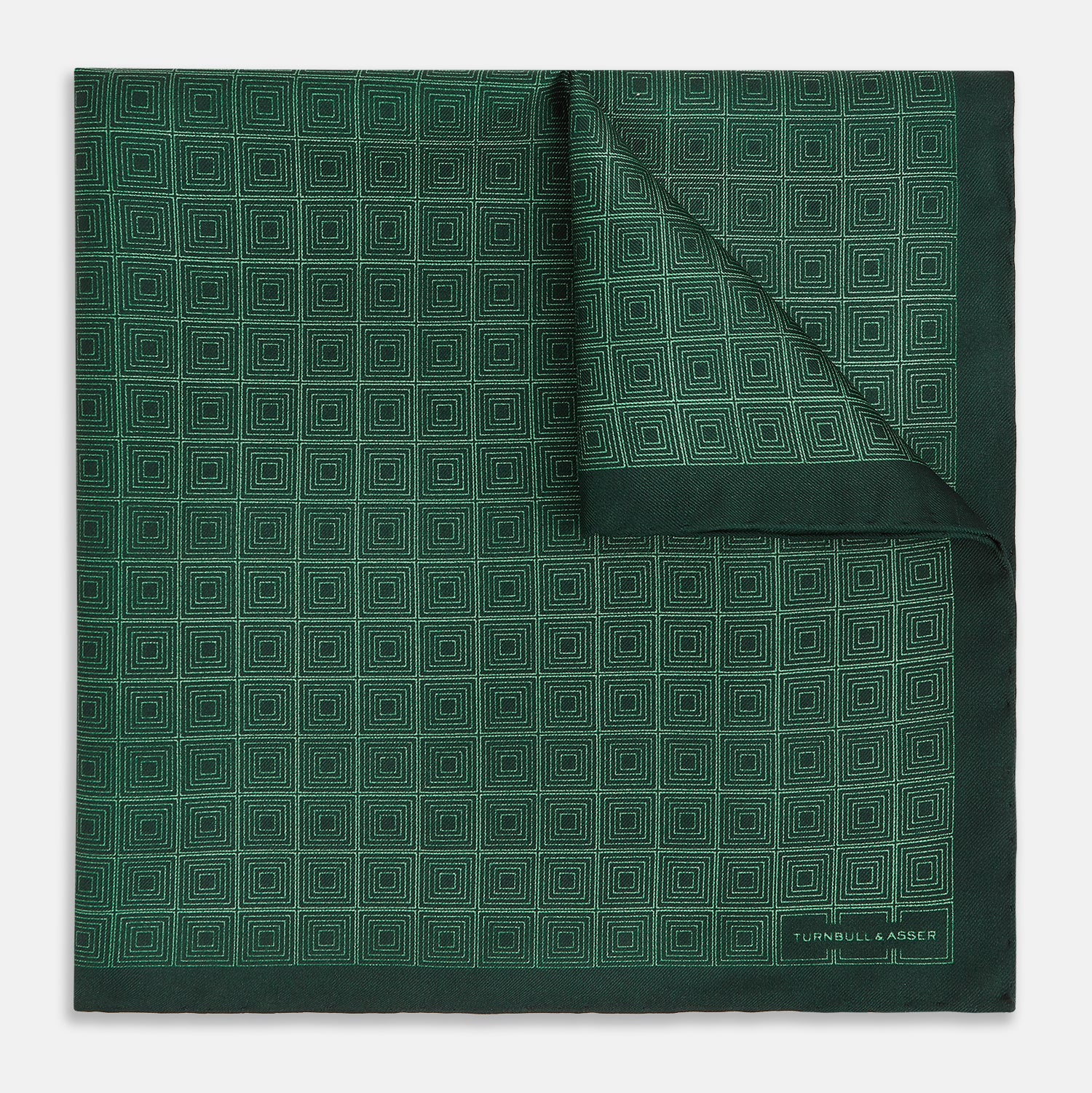 View 1 of product The Geometric Green Pocket Square in Silk by Turnbull & Asser UK features a sophisticated forest green hue with a geometric pattern of concentric squares and a visible Turnbull & Asser label in the corner.