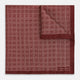 The Geometric Burgundy Pocket Square in Silk by Turnbull & Asser UK features a refined pattern of small, repeating white squares on a rich burgundy background—an ideal accessory for introducing sophistication to any outfit. One corner is artfully folded over to showcase the reverse side of this elegant geometric design, and the "Turnbull & Asser" label appears in the bottom right corner.