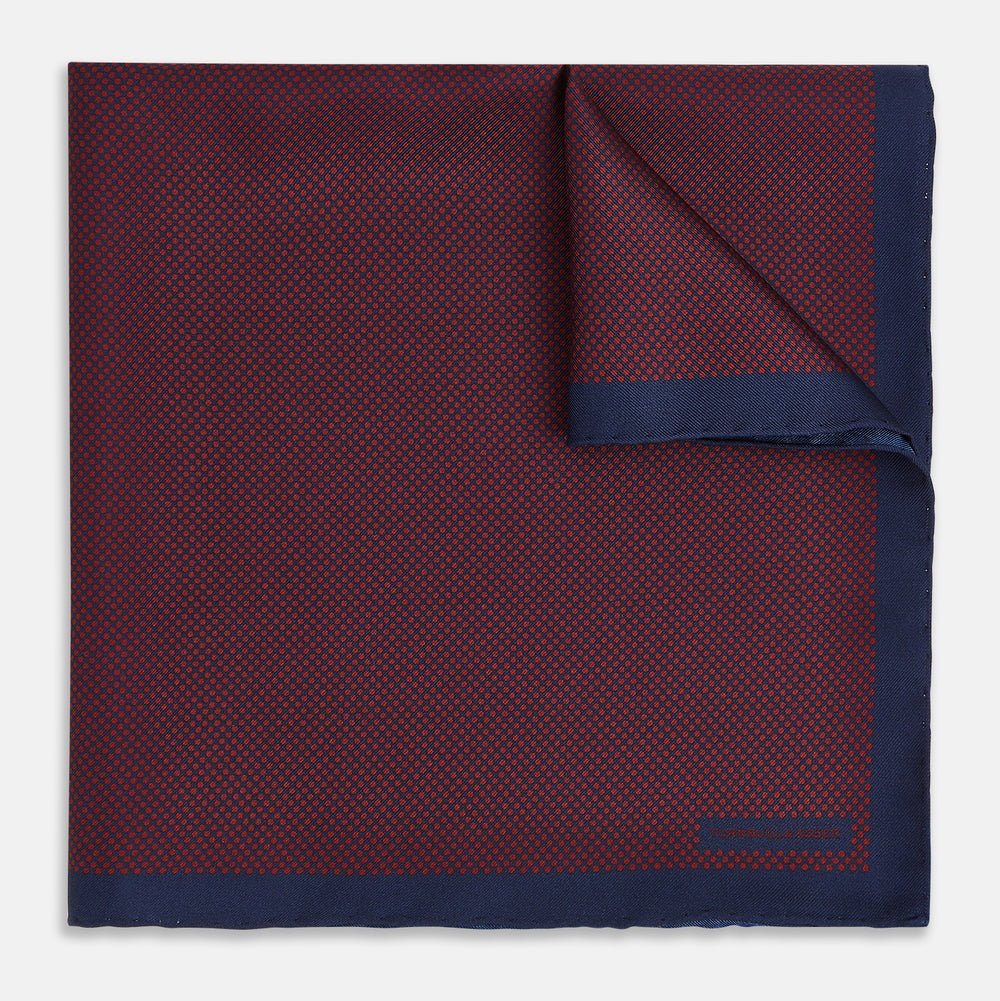 A Polka dot Burgundy Pocket Square in Silk by Turnbull & Asser UK, featuring a subtle micro motif and a solid navy border, partially folded at the top right corner.