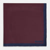 View 3 of product A Polka dot Burgundy Pocket Square in Silk by Turnbull & Asser UK, featuring a subtle micro motif and a solid navy border, partially folded at the top right corner.