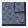 View 1 of product Introducing the Geometric Navy Pocket Square in Silk by Turnbull & Asser UK. This sophisticated accessory showcases a small, repeating geometric pattern in light blue and white on a rich navy background. The pocket square features a solid navy border, while the folded corner reveals the underside adorned with the Turnbull & Asser logo—an elegant finishing touch for any formal ensemble.