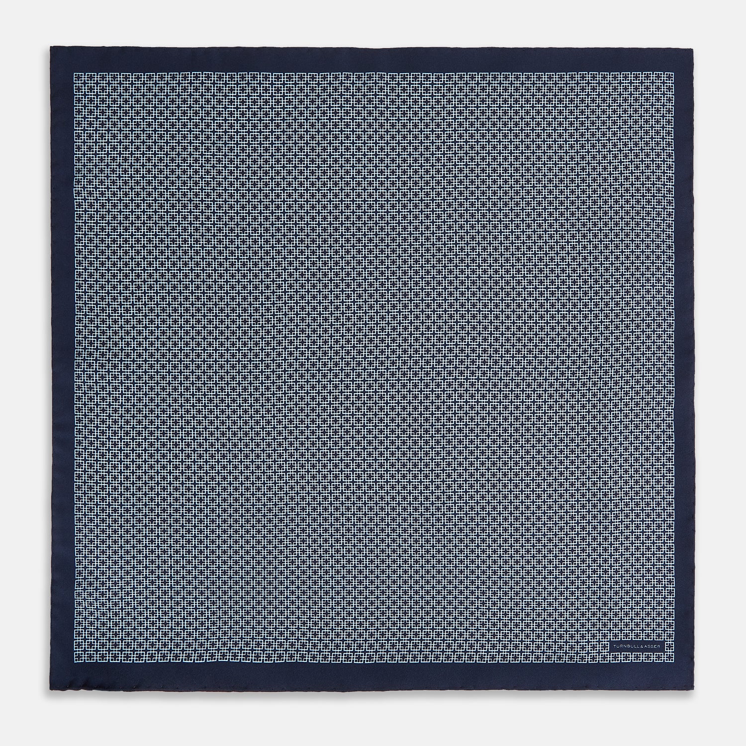 View 4 of product Introducing the Geometric Navy Pocket Square in Silk by Turnbull & Asser UK. This sophisticated accessory showcases a small, repeating geometric pattern in light blue and white on a rich navy background. The pocket square features a solid navy border, while the folded corner reveals the underside adorned with the Turnbull & Asser logo—an elegant finishing touch for any formal ensemble.