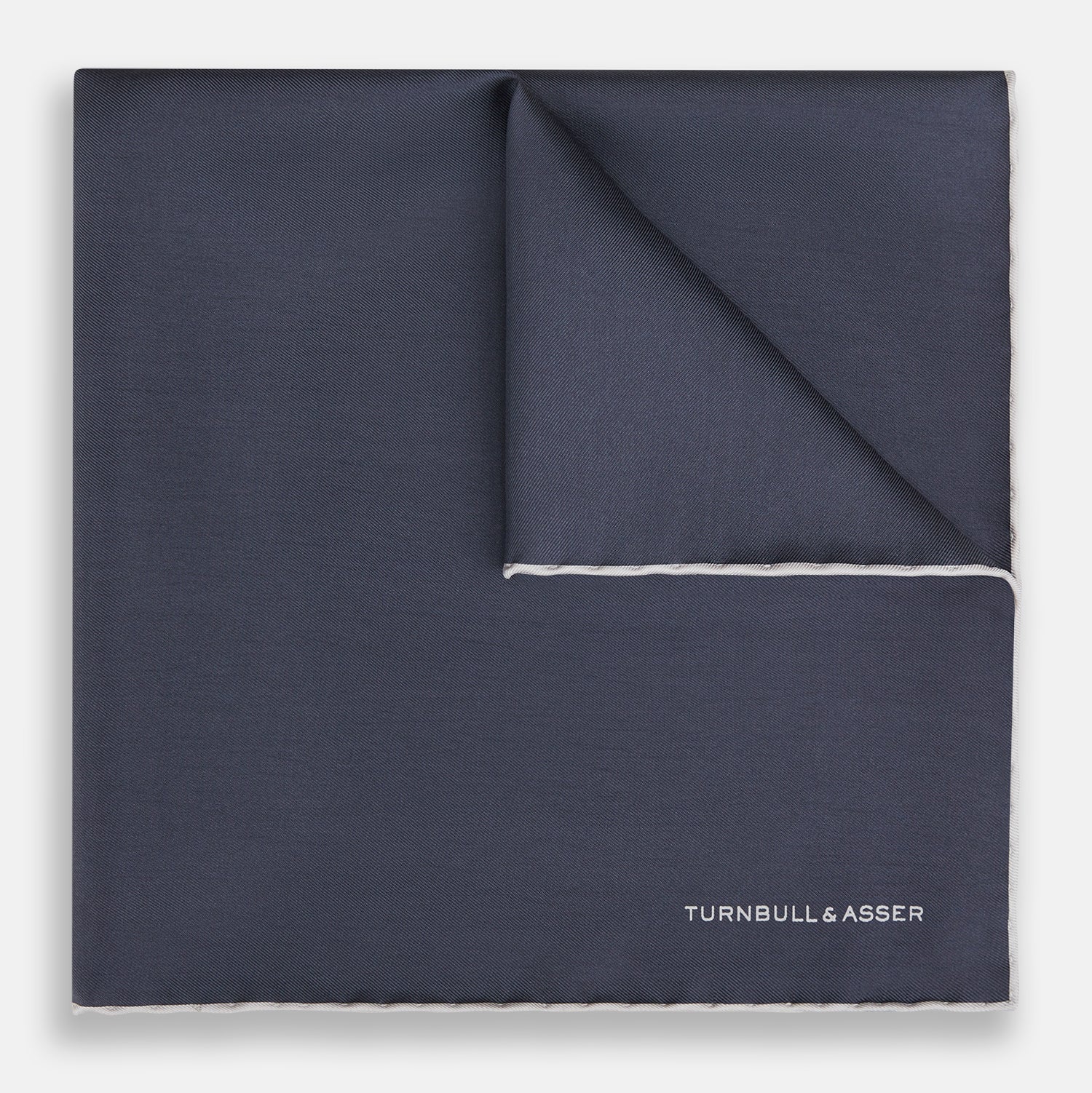 View 1 of product A neatly folded grey silk pocket square with ecru piping—ideal for formal wear—and TURNBULL & ASSER printed in white in one corner.