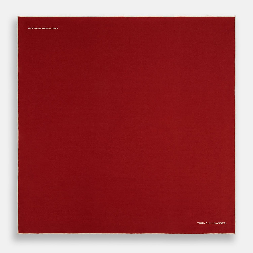 The Turnbull & Asser Burgundy and Ecru Piped Silk Pocket Square features a classic square design, contrasting ecru piping on the edge, and white branding in the lower corner—a refined accessory for formal looks.