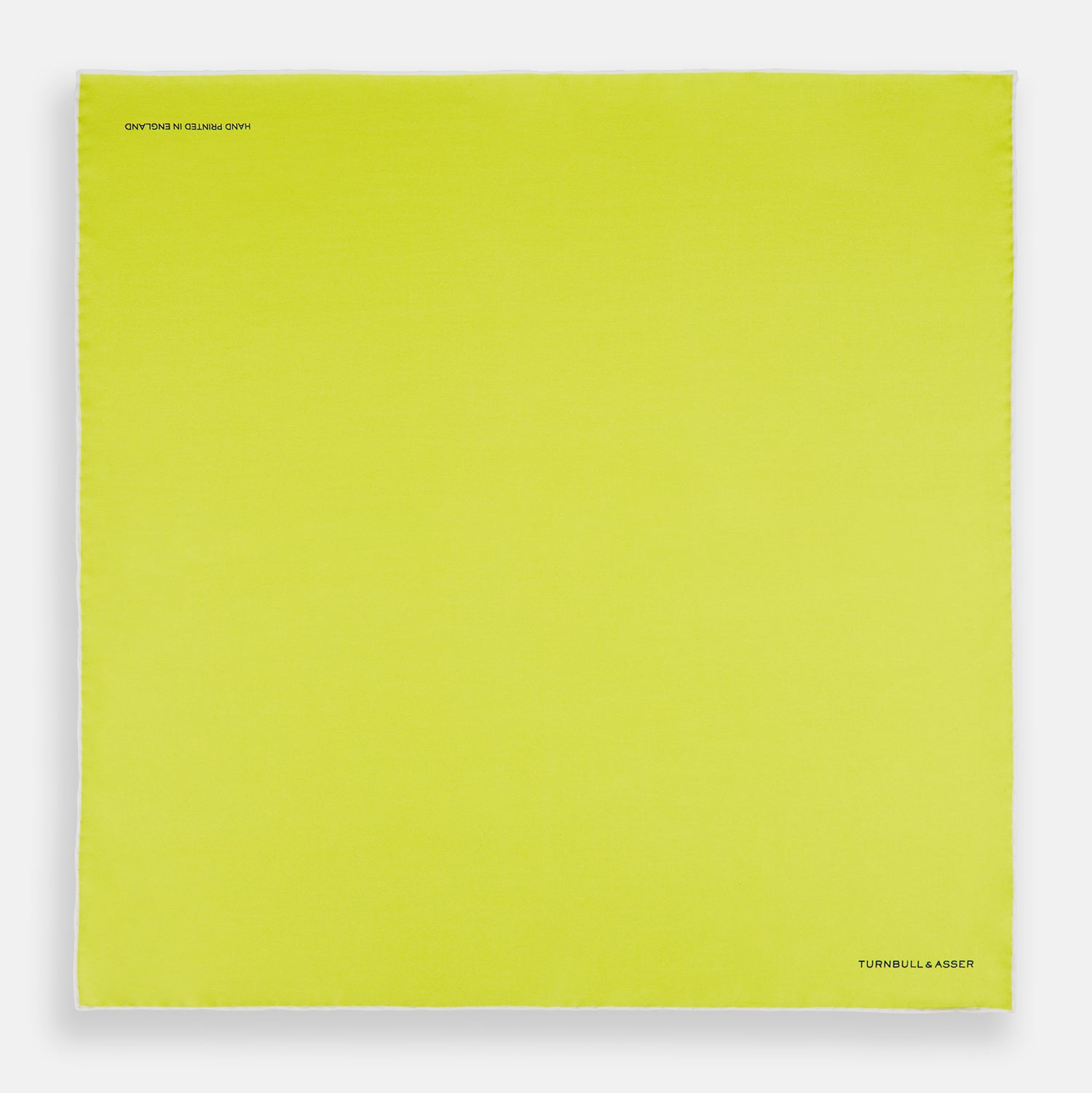 View 4 of product The Canary Yellow Piped Silk Pocket Square by Turnbull & Asser features white edges and black branding in the bottom right corner, making it a perfect accessory for formal attire. Shown on a plain white background.