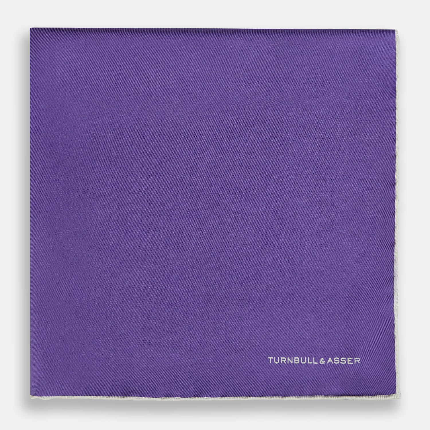 View 3 of product The Turnbull & Asser Violet and Ecru Piped Silk Pocket Square features a stitched edge and white brand logo, making it an elegant addition to formalwear.
