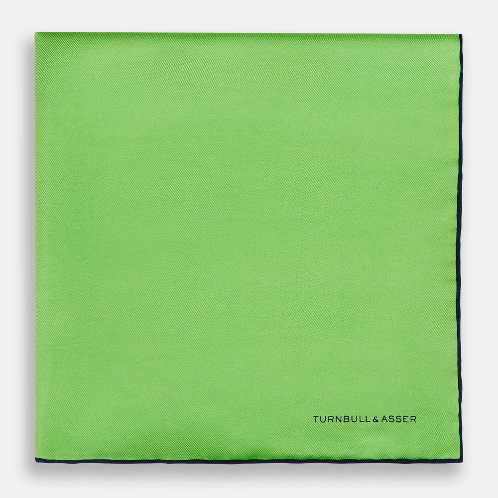 A neatly folded Turnbull & Asser LIGHT GREEN AND BLACK PIPED SILK POCKET SQUARE—ideal for elevating formal attire.
