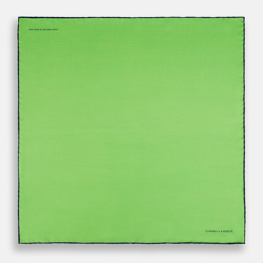 A neatly folded Turnbull & Asser LIGHT GREEN AND BLACK PIPED SILK POCKET SQUARE—ideal for elevating formal attire.