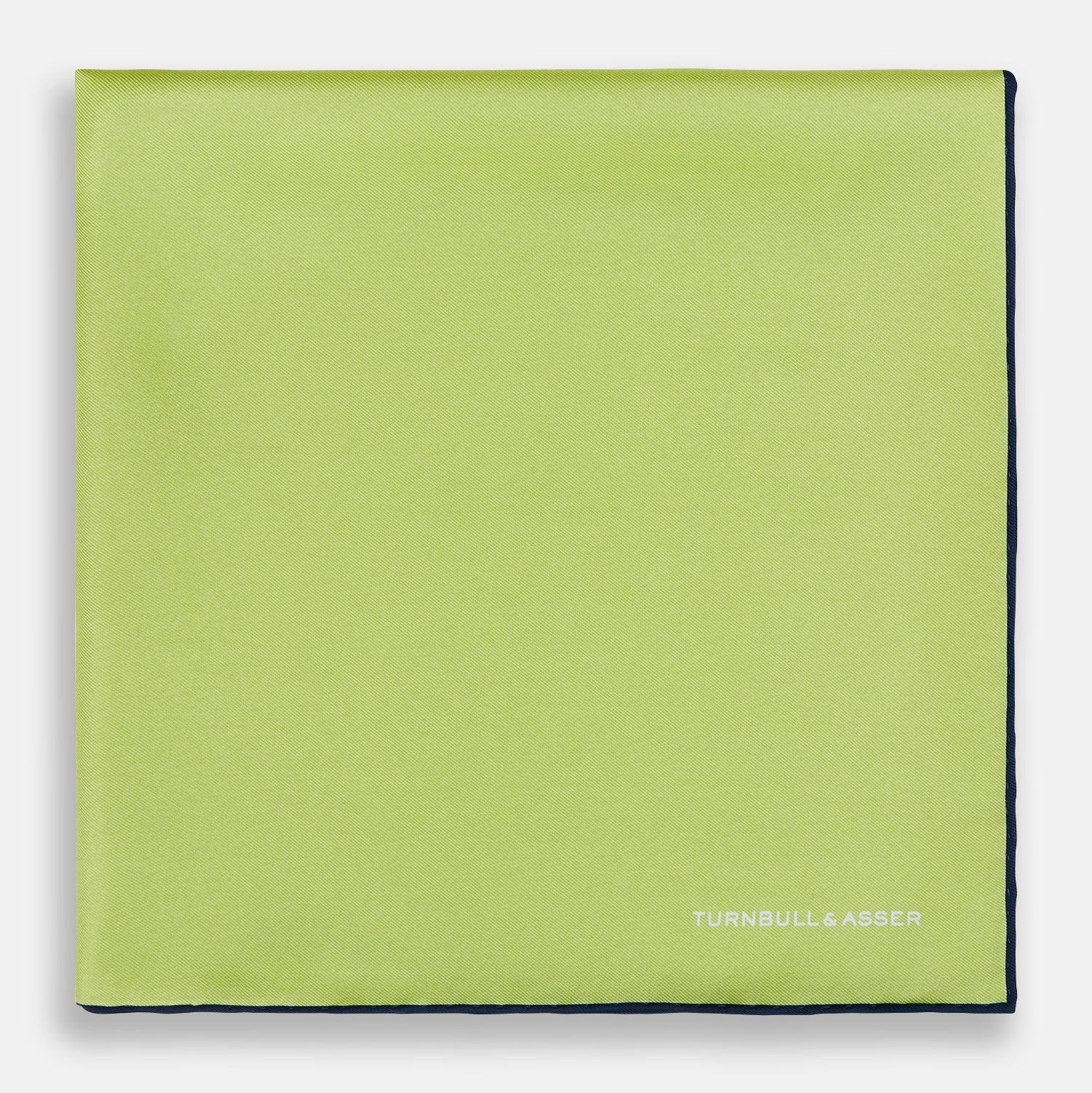 View 3 of product The Pistachio Green and Navy Piped Silk Pocket Square by Turnbull & Asser features crisp navy edging and an elegant brand logo, making it a refined addition to any formal outfit.