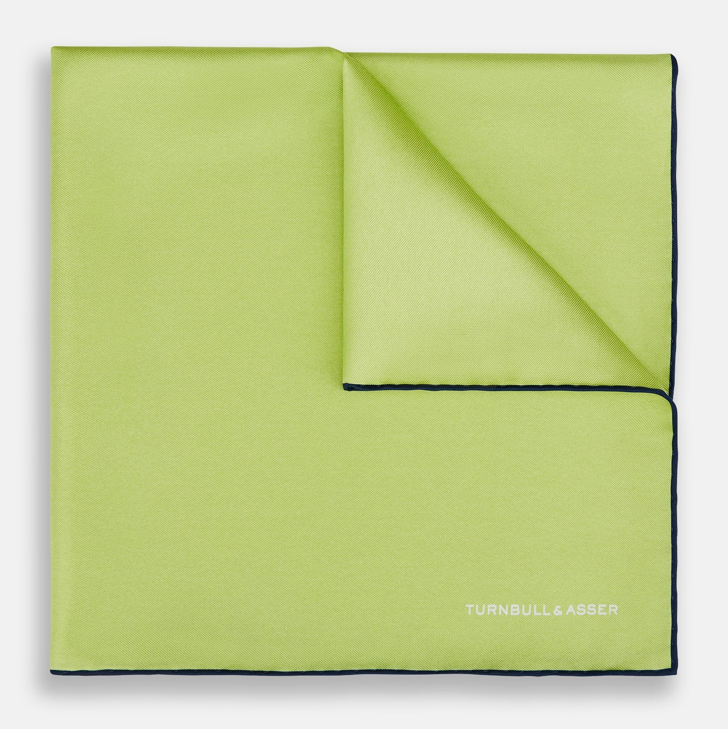 View 1 of product The Pistachio Green and Navy Piped Silk Pocket Square by Turnbull & Asser features crisp navy edging and an elegant brand logo, making it a refined addition to any formal outfit.