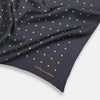 View 2 of product A grey and lime spot silk pocket square by Turnbull & Asser, featuring evenly spaced dots and the brand's logo in one corner—perfect for adding a stylish touch to formal attire.