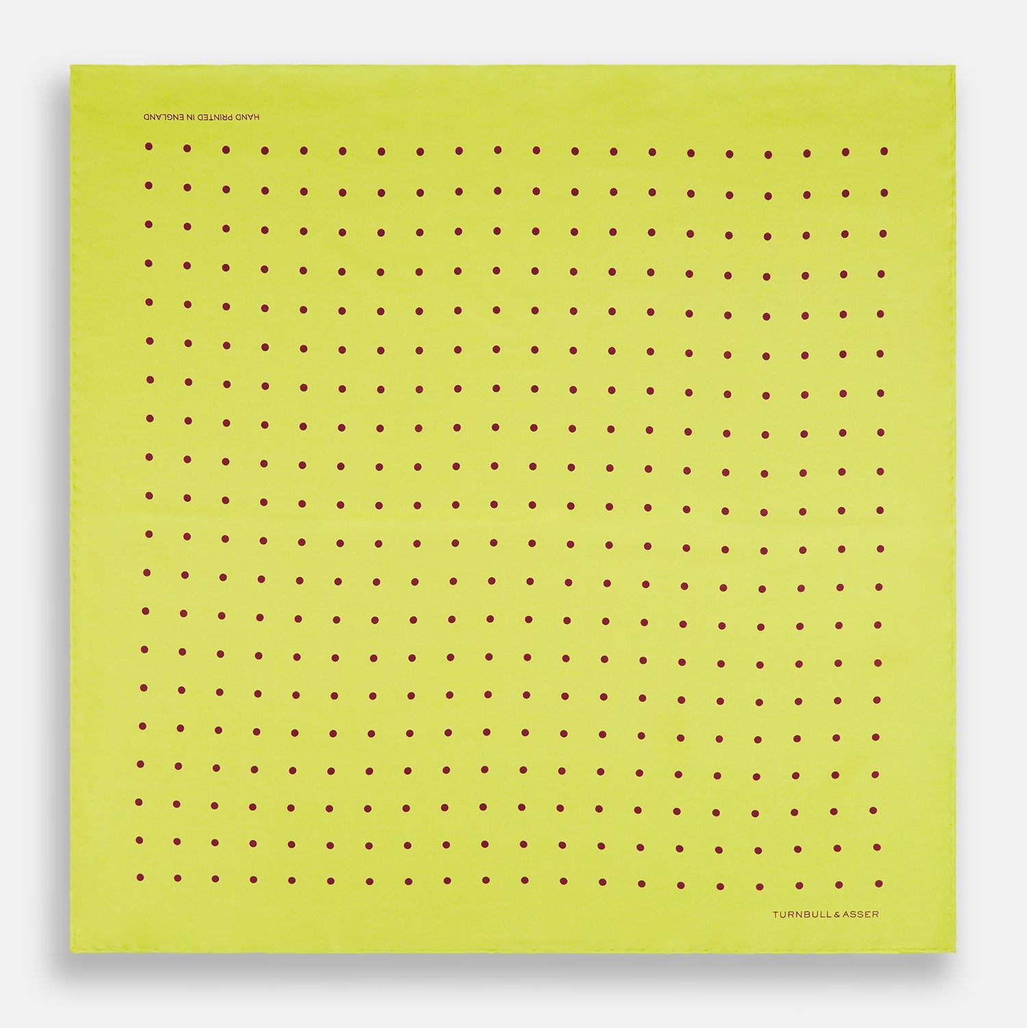 View 4 of product The Turnbull & Asser Chartreuse and Mauve Spot Silk Pocket Square features evenly spaced mauve dots and a branded corner—an ideal accessory to enhance your formal look.