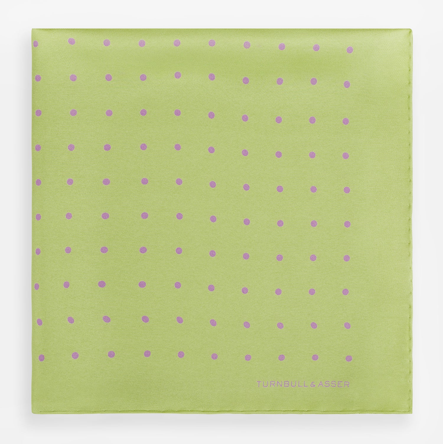 View 3 of product The Turnbull & Asser Melon Green and Lilac Spot Silk Pocket Square features evenly spaced lilac dots and the brand's name in one corner—a refined accessory for formal attire.