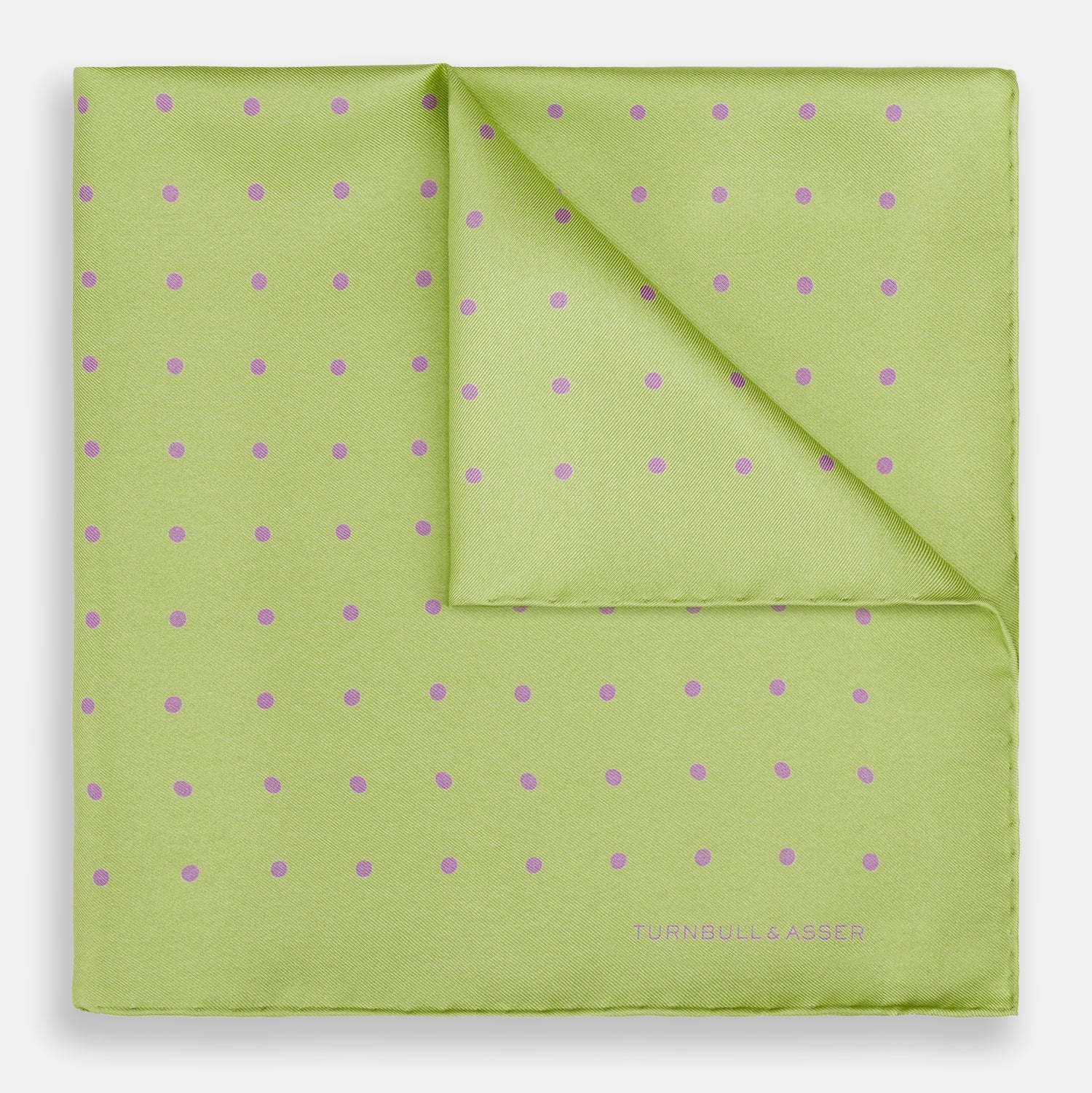 View 1 of product The Turnbull & Asser Melon Green and Lilac Spot Silk Pocket Square features evenly spaced lilac dots and the brand's name in one corner—a refined accessory for formal attire.