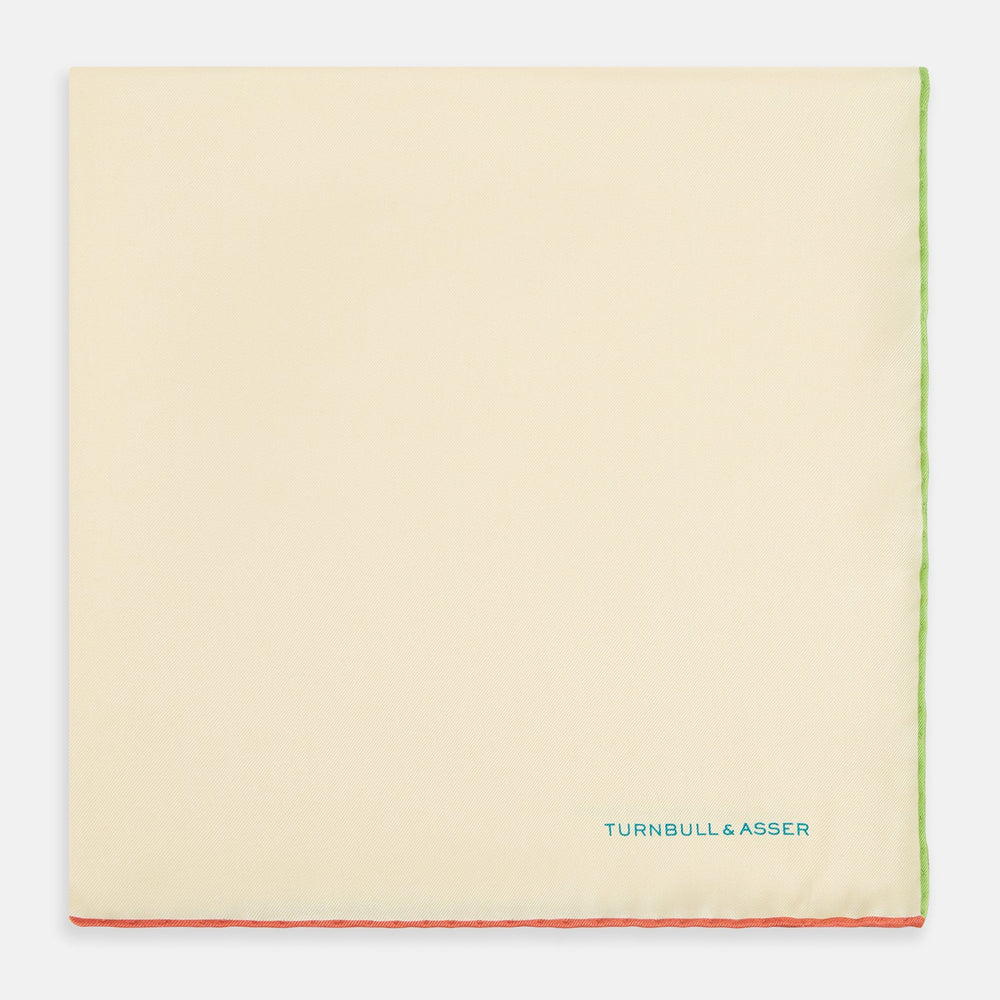 The Turnbull & Asser Ecru and Multicoloured Piped Silk Pocket Square features green and orange piping, blue "TURNBULL & ASSER" embroidery in the lower right, and a folded corner—a refined accessory for formal wear.