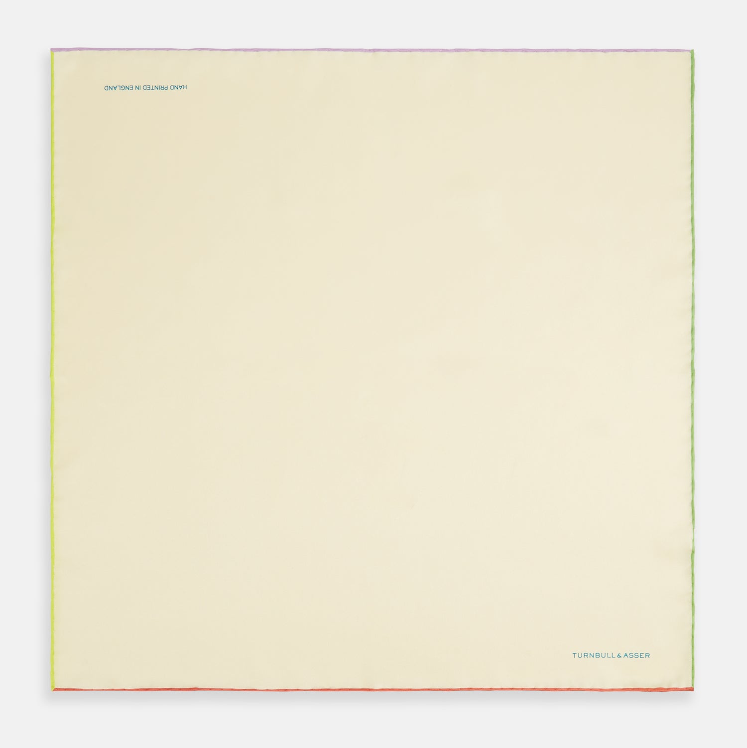 View 4 of product The Turnbull & Asser Ecru and Multicoloured Piped Silk Pocket Square features green and orange piping, blue "TURNBULL & ASSER" embroidery in the lower right, and a folded corner—a refined accessory for formal wear.