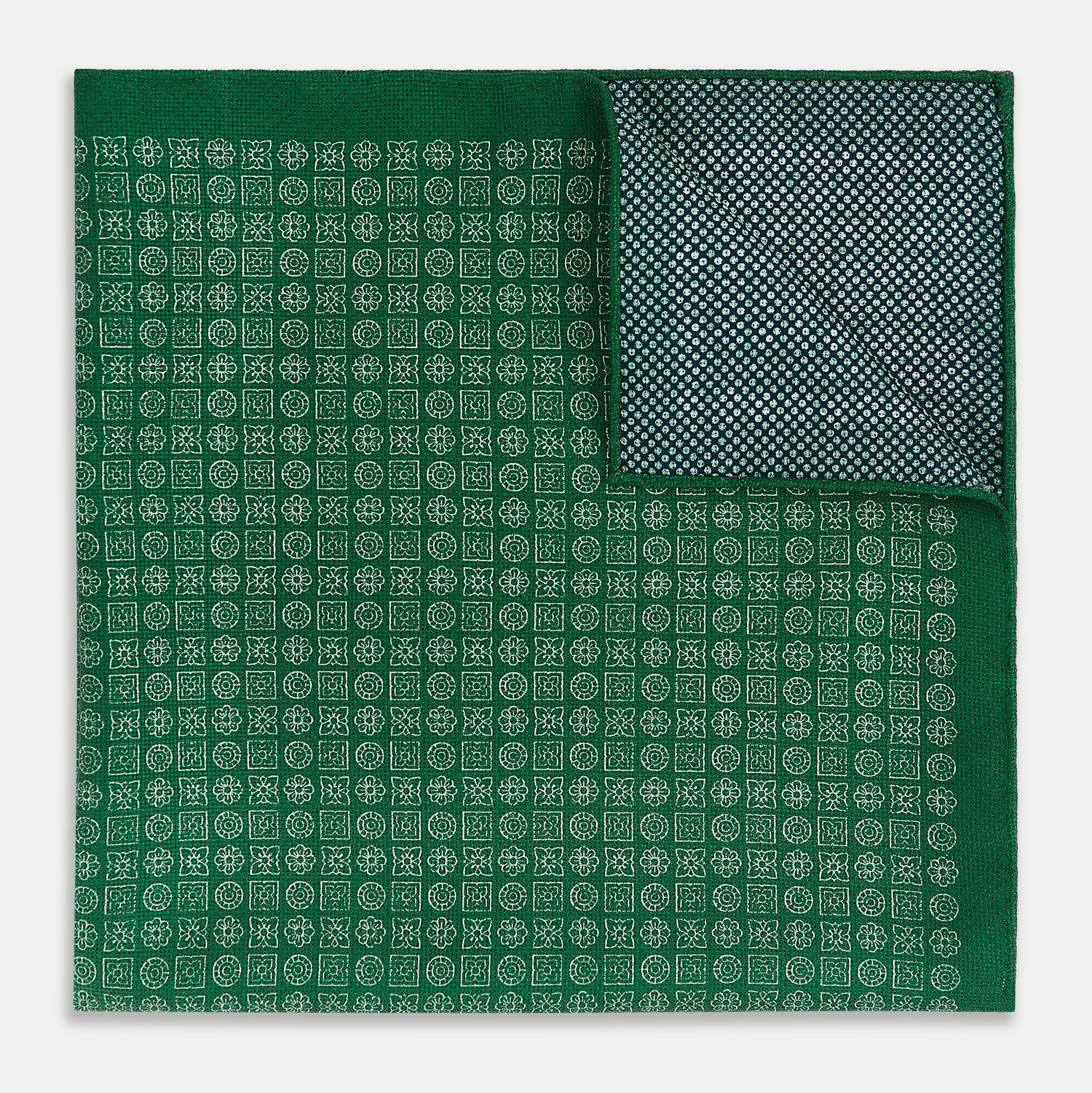 View 1 of product The Rosette Green Pocket Square in Silk by Turnbull & Asser UK features a small geometric medallion pattern and is shown folded to display a contrasting fine black-and-white design on the reverse side.