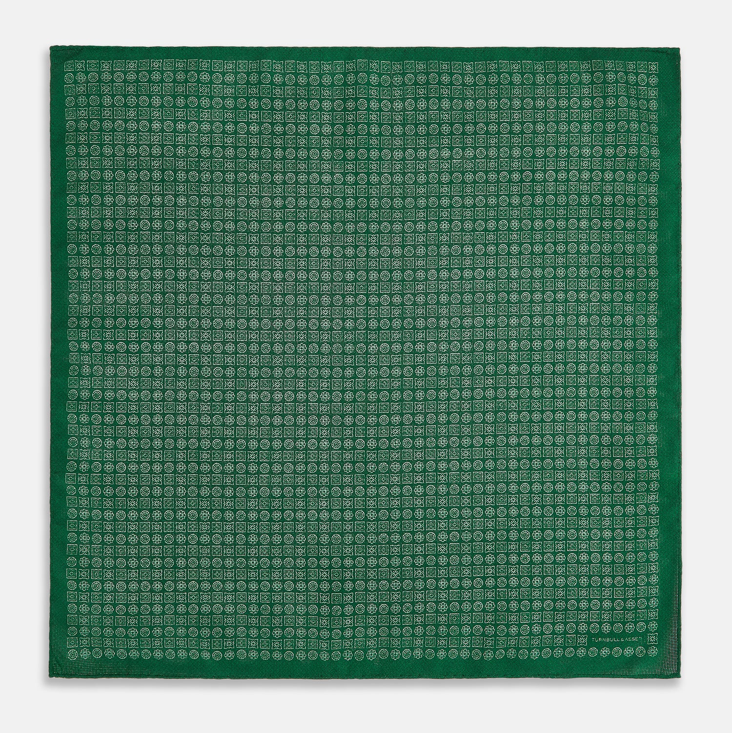 View 5 of product The Rosette Green Pocket Square in Silk by Turnbull & Asser UK features a small geometric medallion pattern and is shown folded to display a contrasting fine black-and-white design on the reverse side.
