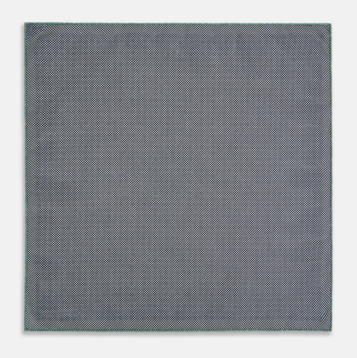 View 6 of product A square silk pocket square in Rosette Green by Turnbull & Asser UK, featuring a teal base with a grid of dark dots. One corner is folded to showcase the black and white microdot pattern on the reverse, while subtle hints of navy, aqua, and green form geometric medallions that lend a refined modern touch.