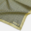 View 3 of product The Rosette Yellow Pocket Square in Silk by Turnbull & Asser UK features a square design with a yellow border, adorned with a grid of small black and white circles. One corner is neatly folded to reveal a reverse side in a refined black and white micro-checkered pattern, while subtle geometric medallions lend an added touch of elegance to the overall look.