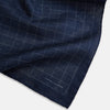 View 3 of product The Checked Blue Pocket Square in Silk by Turnbull & Asser UK features a navy base with a light blue grid pattern on one side and a refined dotted design on the other. This double-sided accessory is shown partially folded to elegantly showcase both distinctive patterns.