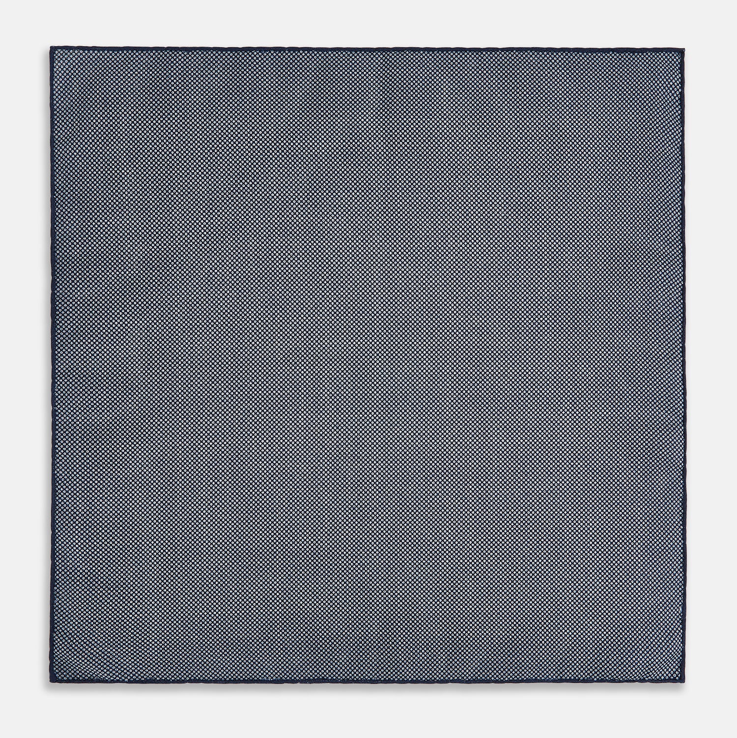View 6 of product The Checked Blue Pocket Square in Silk by Turnbull & Asser UK features a navy base with a light blue grid pattern on one side and a refined dotted design on the other. This double-sided accessory is shown partially folded to elegantly showcase both distinctive patterns.